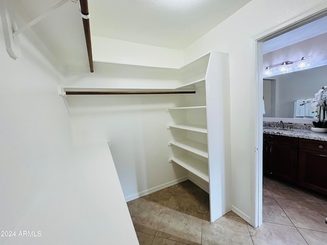 walk in closet with light tile patterned flooring and sink