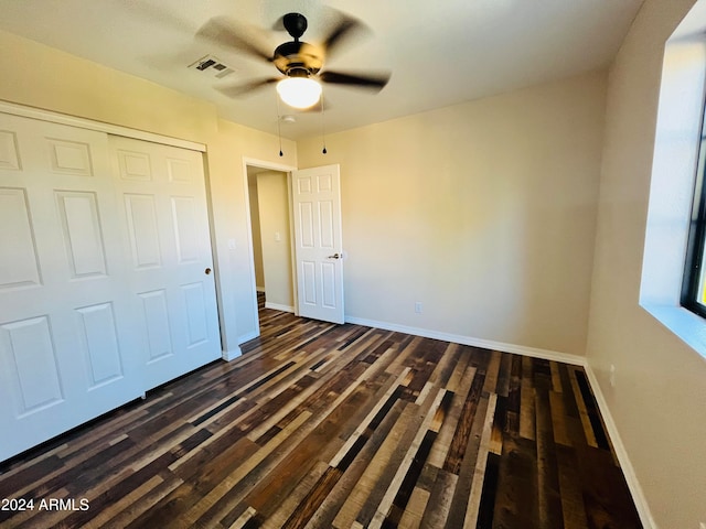 unfurnished bedroom featuring dark hardwood / wood-style flooring, a closet, and ceiling fan