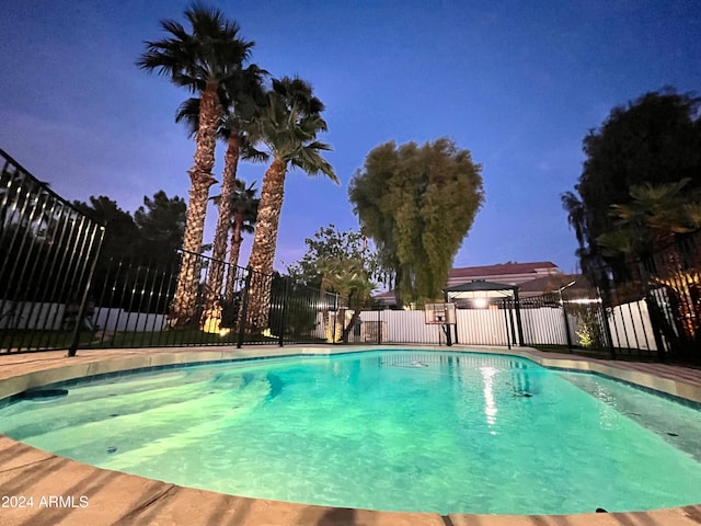 view of pool at dusk