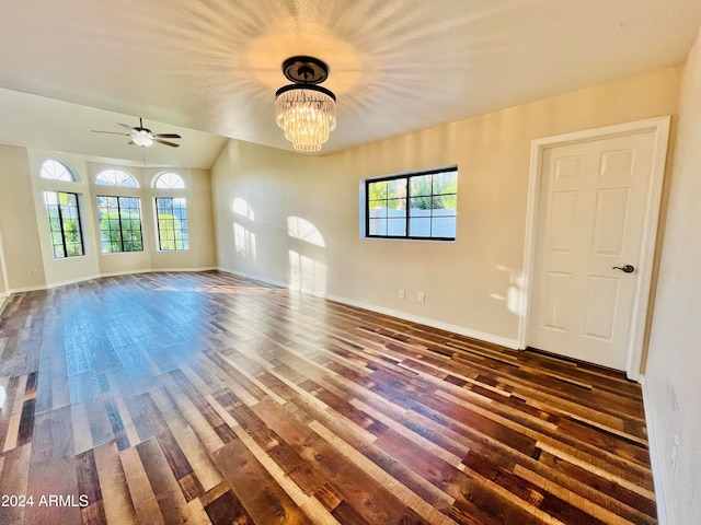 unfurnished living room with ceiling fan with notable chandelier and dark hardwood / wood-style floors