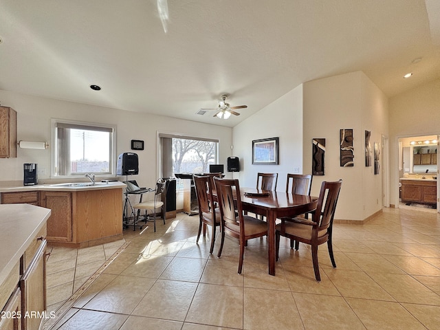 dining room featuring light tile patterned floors, vaulted ceiling, sink, and ceiling fan