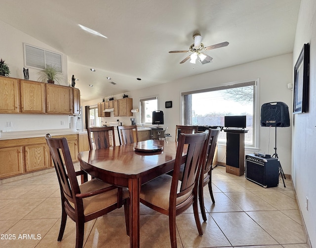 tiled dining space featuring ceiling fan and lofted ceiling