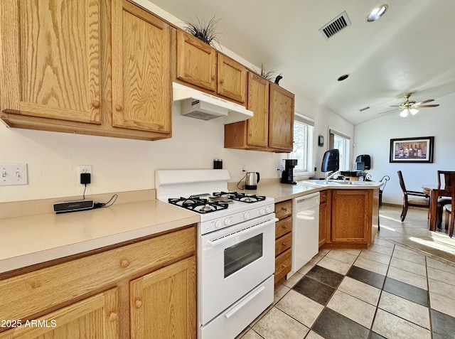 kitchen featuring white appliances, vaulted ceiling, light tile patterned floors, kitchen peninsula, and ceiling fan