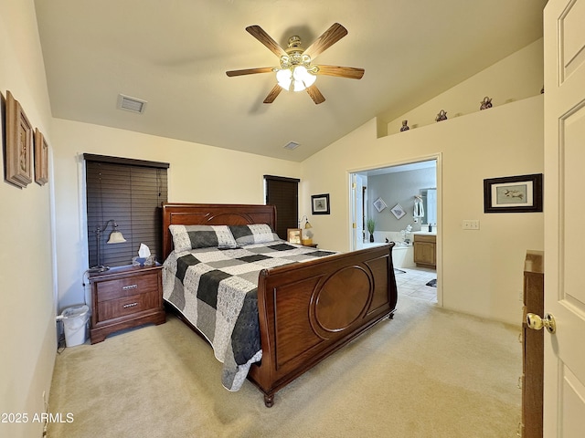 bedroom with lofted ceiling, light carpet, ceiling fan, and ensuite bath