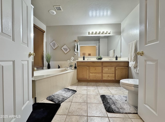 bathroom with vanity, toilet, tile patterned flooring, and a bath