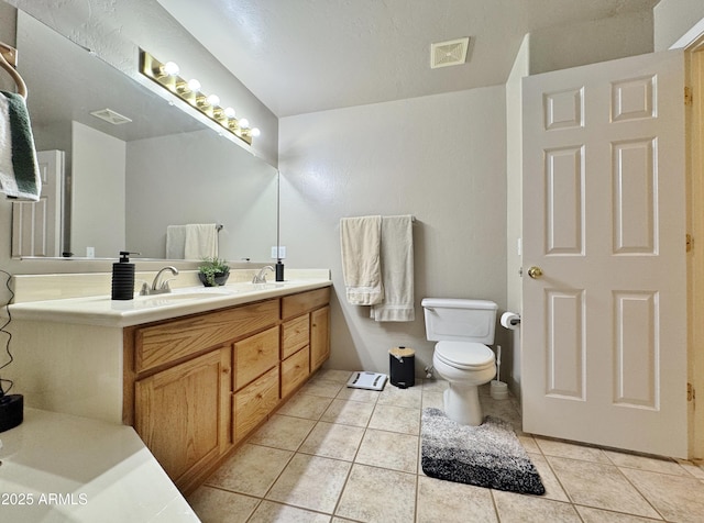 bathroom featuring tile patterned flooring, vanity, and toilet