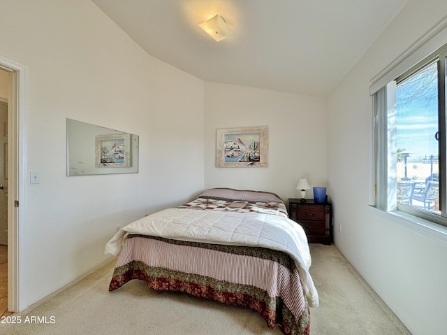 bedroom featuring vaulted ceiling and light carpet