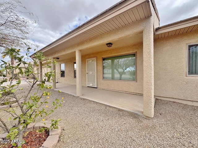 view of exterior entry with a patio area