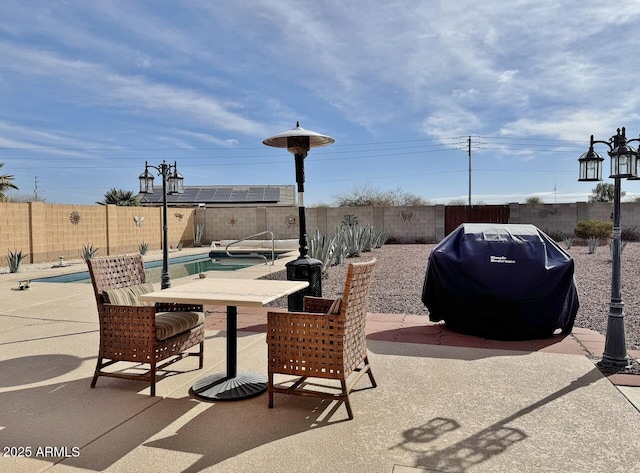 view of patio / terrace with a fenced in pool and a grill