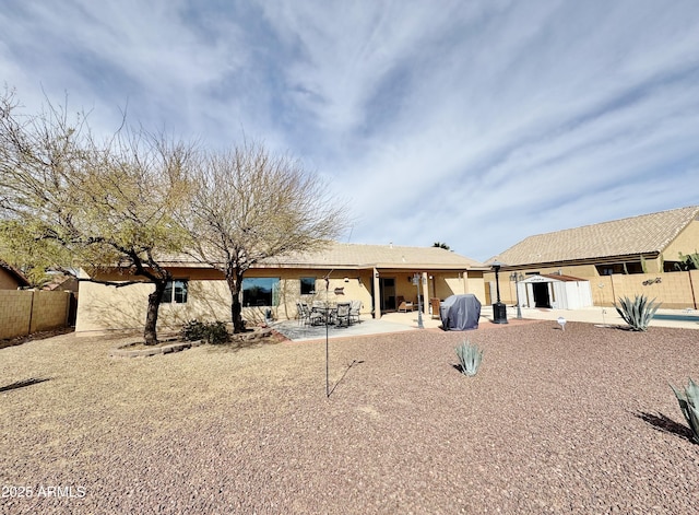 back of property featuring a storage shed and a patio area