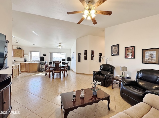 living room with lofted ceiling, sink, light tile patterned floors, and ceiling fan