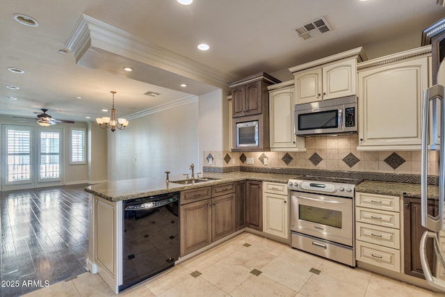 2470 E Roma Ave, Phoenix, AZ 85016 - kitchen featuring stainless steel appliances, crown molding, cream cabinets, a peninsula, and decorative backsplash