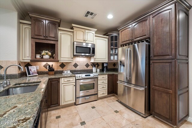 2470 E Roma Ave, Phoenix, AZ 85016 - kitchen featuring stainless steel appliances, dark stone counters, decorative backsplash, dark brown cabinetry, and recessed lighting