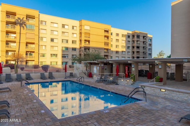 community pool featuring fence and a patio