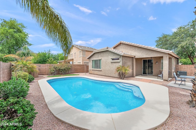 view of swimming pool with ceiling fan, central AC unit, and a patio