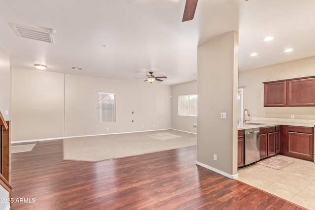 kitchen with ceiling fan, sink, stainless steel dishwasher, and light wood-type flooring