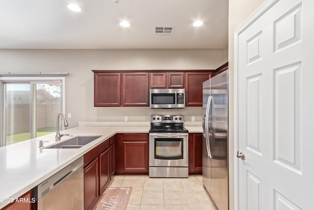 kitchen featuring stainless steel appliances, sink, and light tile patterned floors