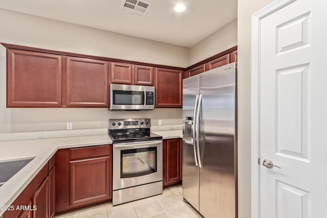 kitchen with appliances with stainless steel finishes, sink, and light tile patterned floors