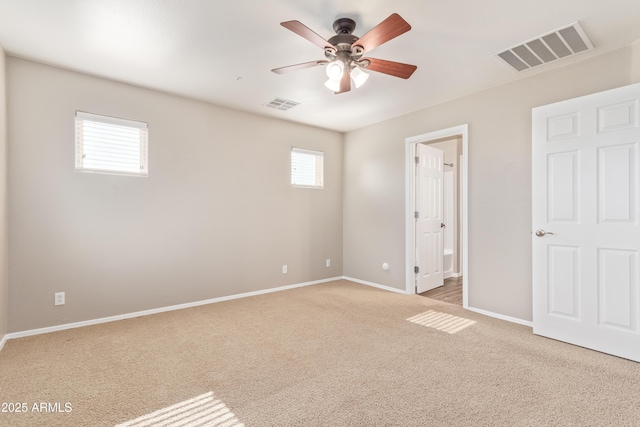 unfurnished bedroom featuring ceiling fan, light colored carpet, and connected bathroom