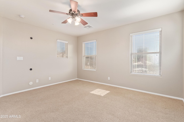 carpeted spare room featuring ceiling fan