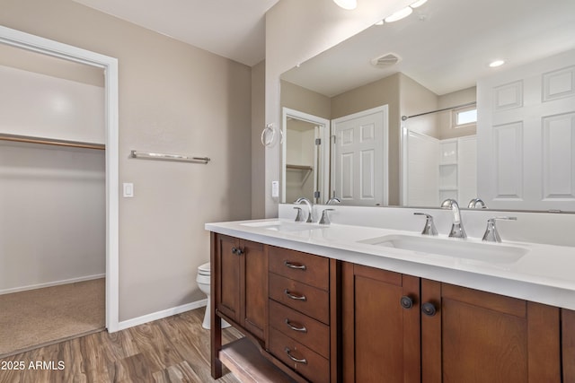 bathroom featuring vanity, toilet, hardwood / wood-style floors, and walk in shower