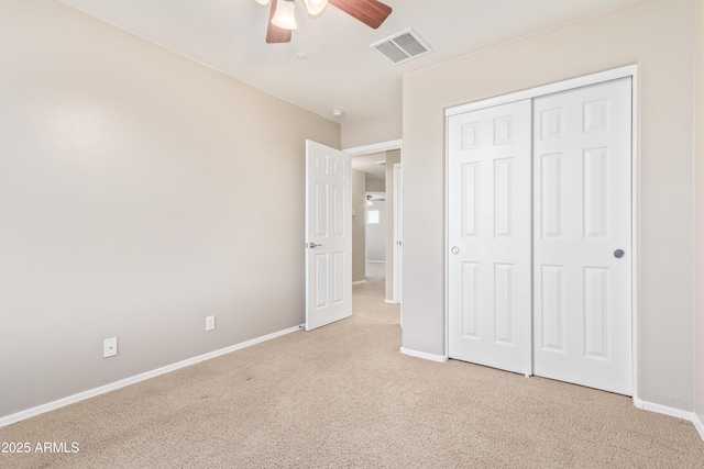 unfurnished bedroom with ceiling fan, light colored carpet, and a closet