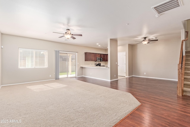 unfurnished living room featuring dark hardwood / wood-style flooring and ceiling fan