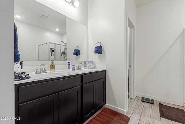 bathroom with a shower with door and vanity