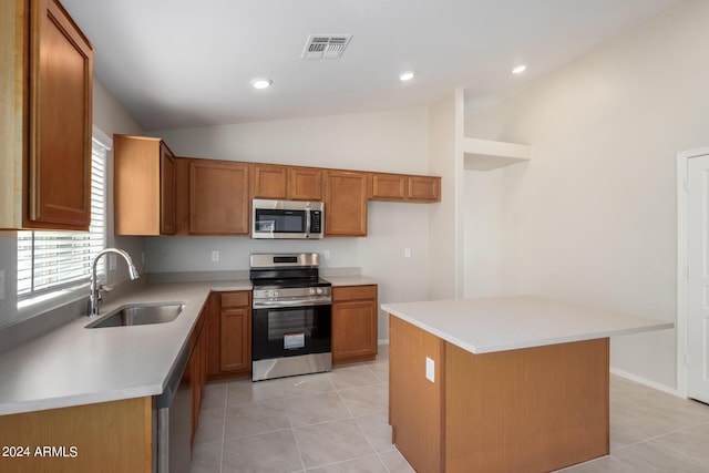 3847 W Yellow Peak Dr, San Tan Valley, AZ 85144 - kitchen featuring visible vents, vaulted ceiling, brown cabinetry, stainless steel appliances, and a sink