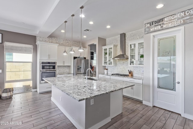 12083 W Peak View Rd, Peoria, AZ 85383 - kitchen with wall chimney range hood, appliances with stainless steel finishes, wood tiled floors, white cabinetry, and recessed lighting