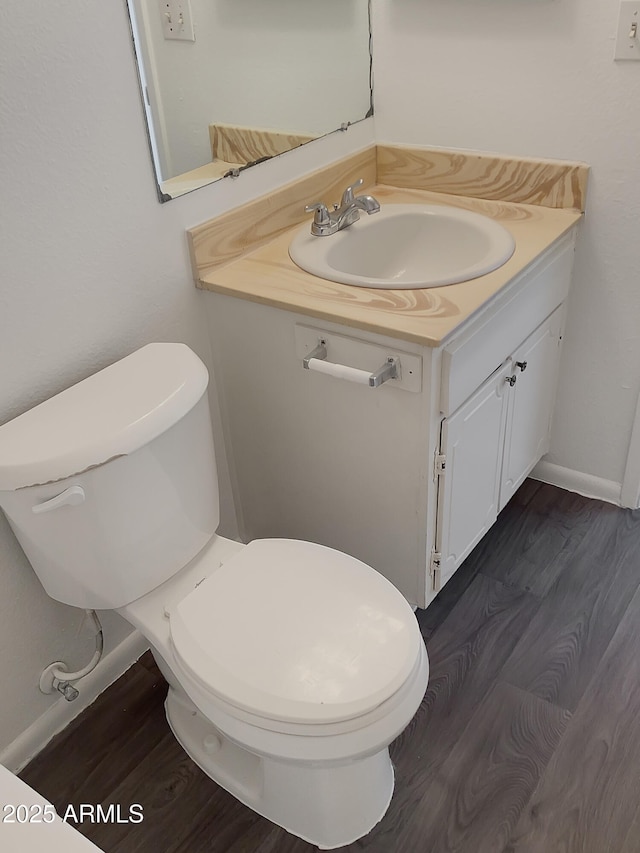 bathroom featuring toilet, wood-type flooring, and vanity