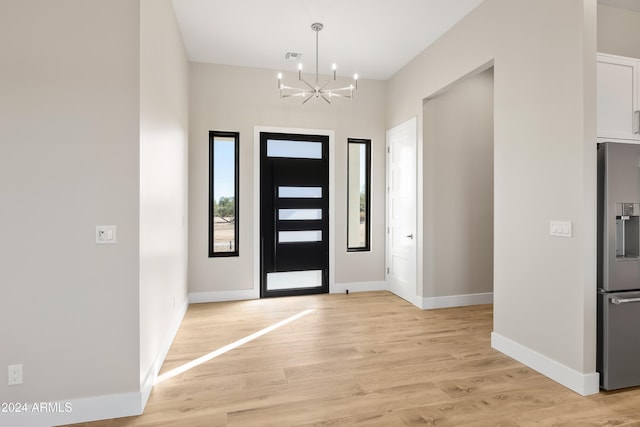 entrance foyer featuring a notable chandelier and light hardwood / wood-style flooring