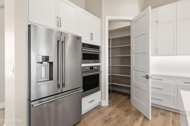 kitchen featuring white cabinetry, stainless steel appliances, and light hardwood / wood-style flooring