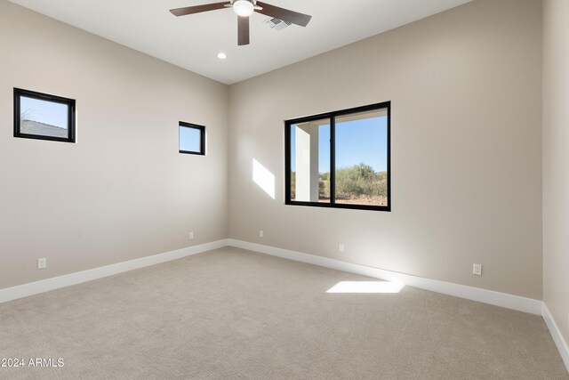 spare room with light carpet and ceiling fan