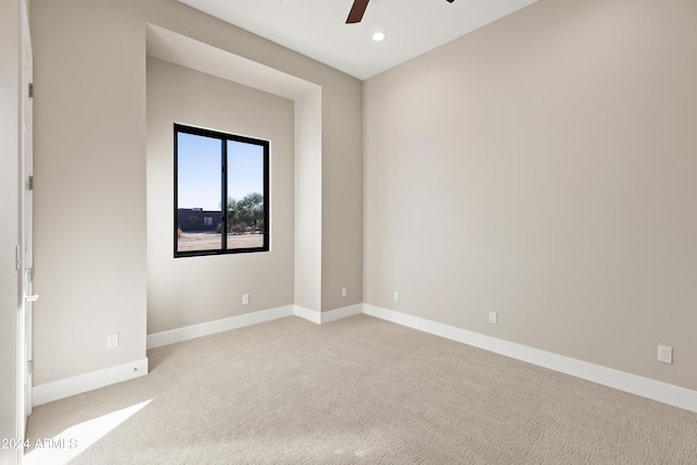 spare room with light colored carpet and ceiling fan