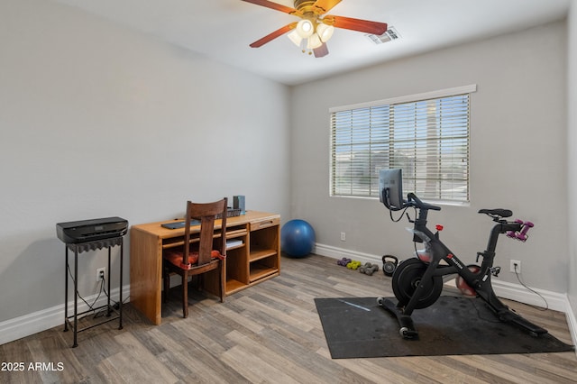 exercise area featuring light wood-style floors, baseboards, visible vents, and a ceiling fan