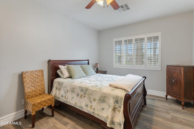 bedroom with visible vents, ceiling fan, baseboards, and wood finished floors