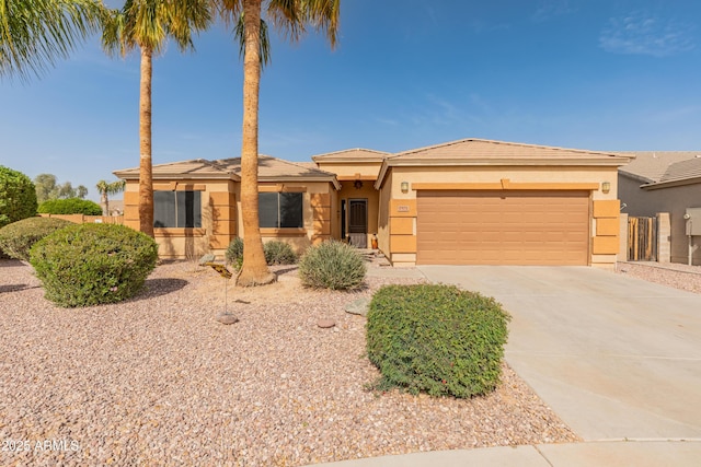 view of front of property with concrete driveway, an attached garage, and stucco siding