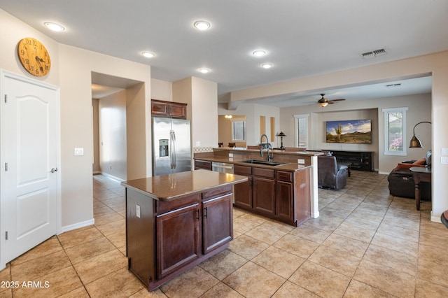 kitchen with a sink, visible vents, open floor plan, appliances with stainless steel finishes, and dark countertops