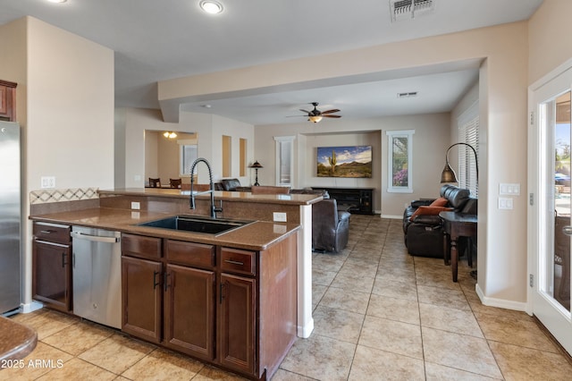 kitchen with a peninsula, a sink, visible vents, open floor plan, and appliances with stainless steel finishes