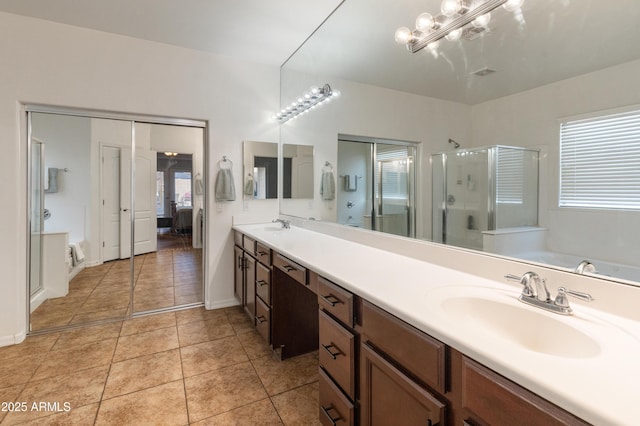 full bathroom featuring a stall shower, tile patterned flooring, a sink, and double vanity