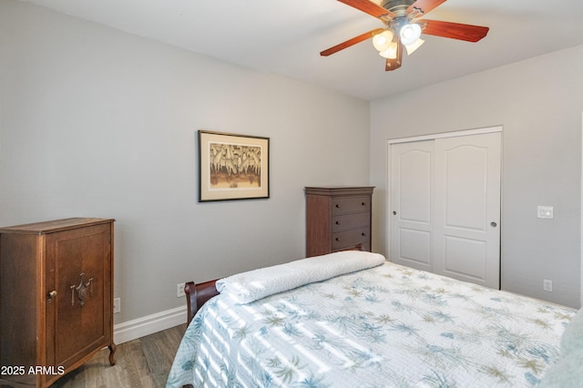 bedroom with ceiling fan, baseboards, a closet, and wood finished floors