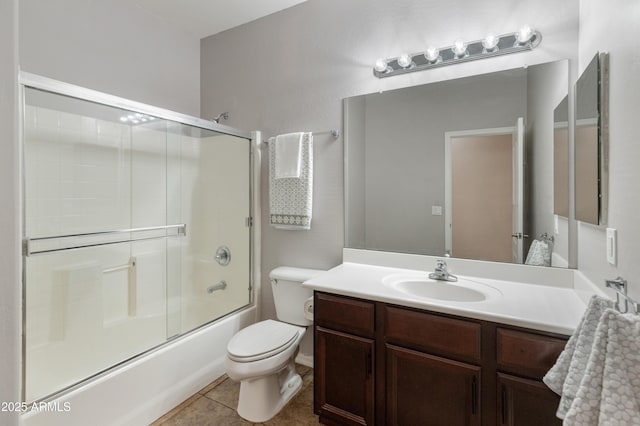 bathroom featuring combined bath / shower with glass door, vanity, toilet, and tile patterned floors