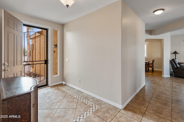 foyer entrance featuring light tile patterned floors and baseboards