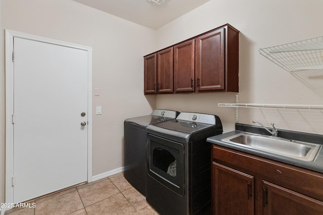 washroom with cabinet space, light tile patterned flooring, a sink, independent washer and dryer, and baseboards