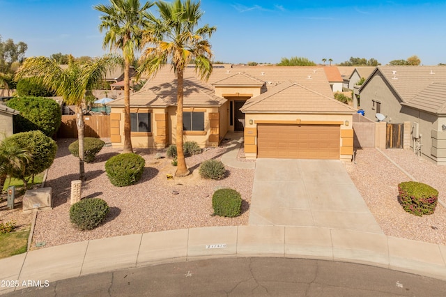 view of front facade featuring driveway, a tile roof, and fence