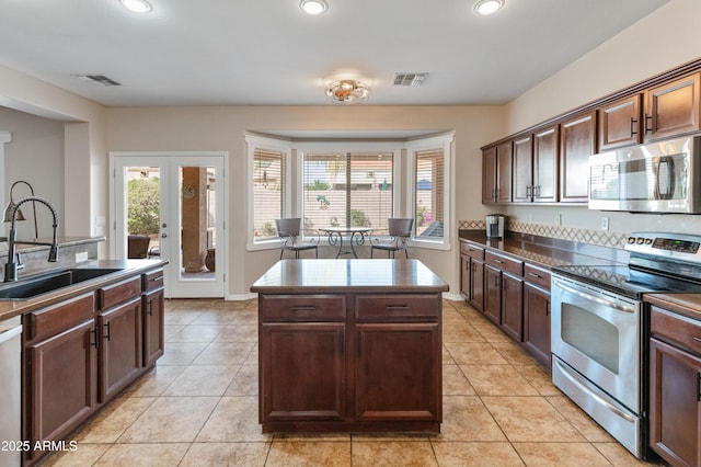 kitchen featuring dark countertops, visible vents, appliances with stainless steel finishes, and a sink