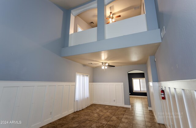 interior space with ceiling fan and a towering ceiling