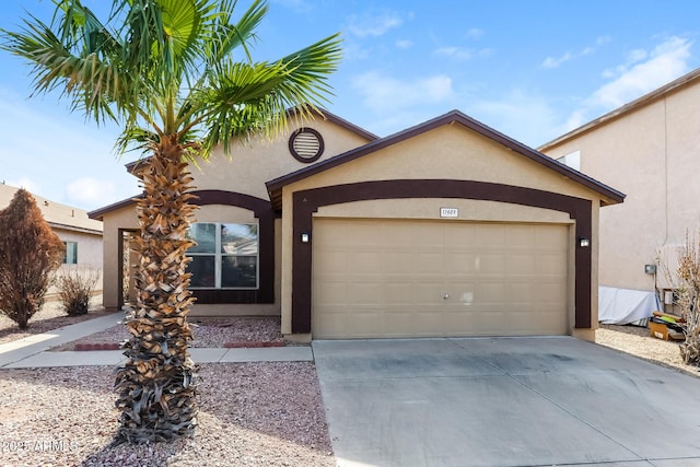 view of front facade with an attached garage, driveway, and stucco siding