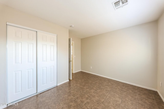 unfurnished bedroom featuring a closet, visible vents, and baseboards